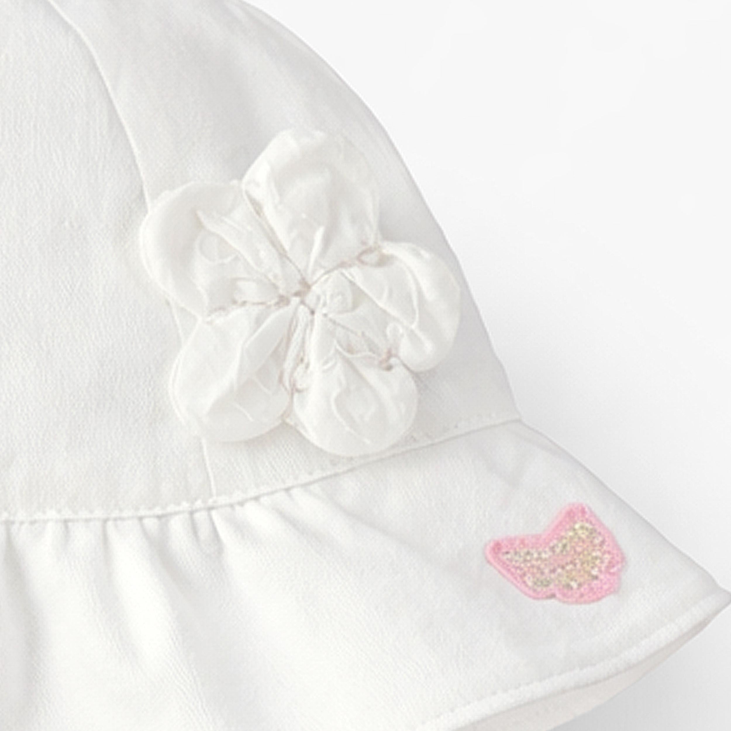 Zoom détails du chapeau cloche blanc avec fleurs, bébé
