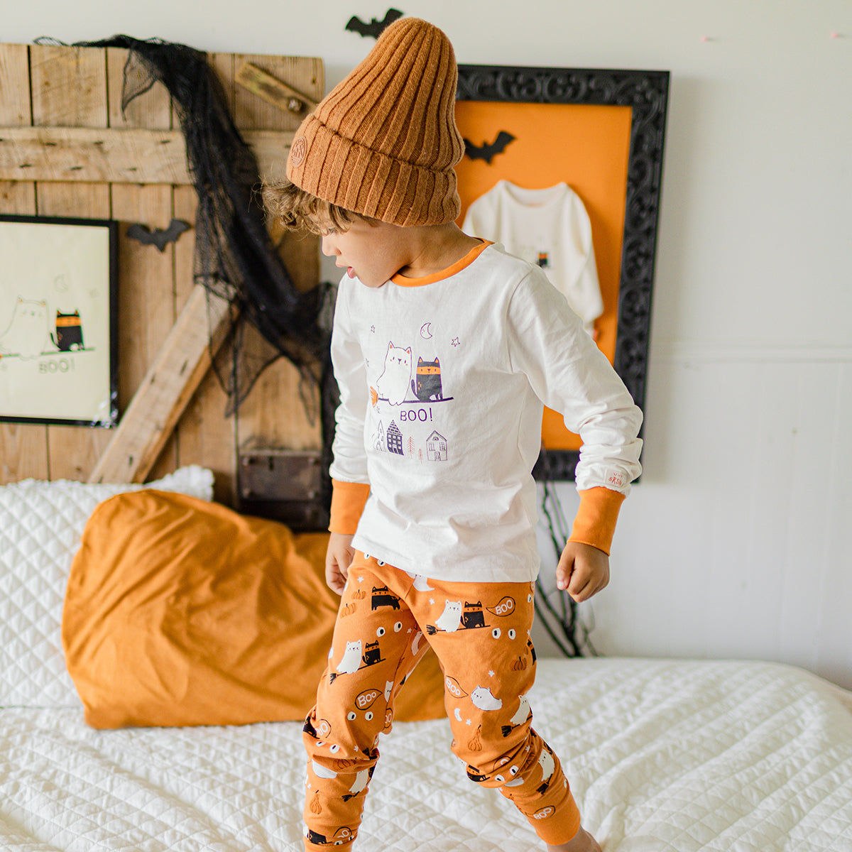 Photo d'un enfant portant le pyjama deux pièces crème et orange à motifs d’Halloween, enfant