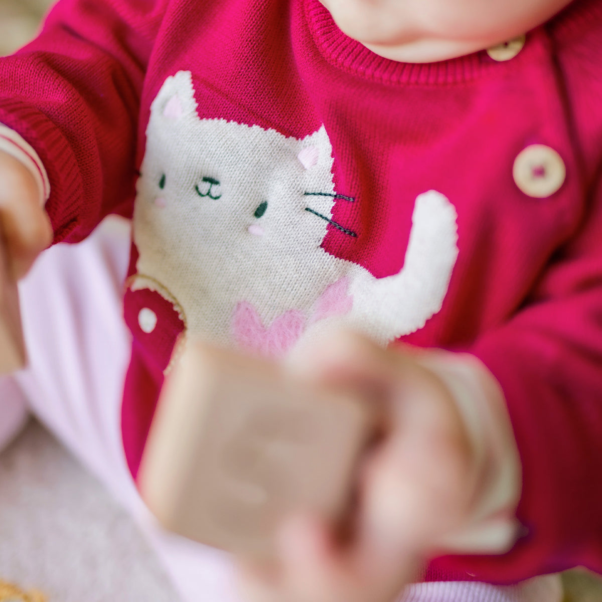 Zoom détails du chandail rose en tricot avec motif jacquard, naissance