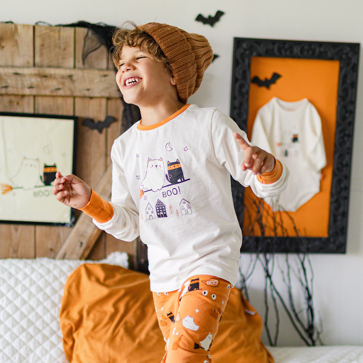 Photo d'un enfant portant le pyjama deux pièces crème et orange à motifs d’Halloween, enfant