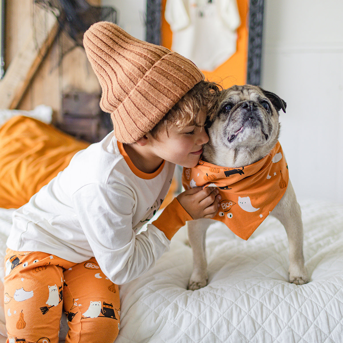 Photo d'un enfant portant le pyjama deux pièces crème et orange à motifs d’Halloween, enfant