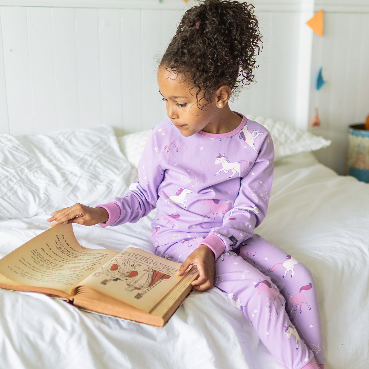 Photo d'un enfant portant le pyjama deux pièces mauve à motifs de licornes, enfant