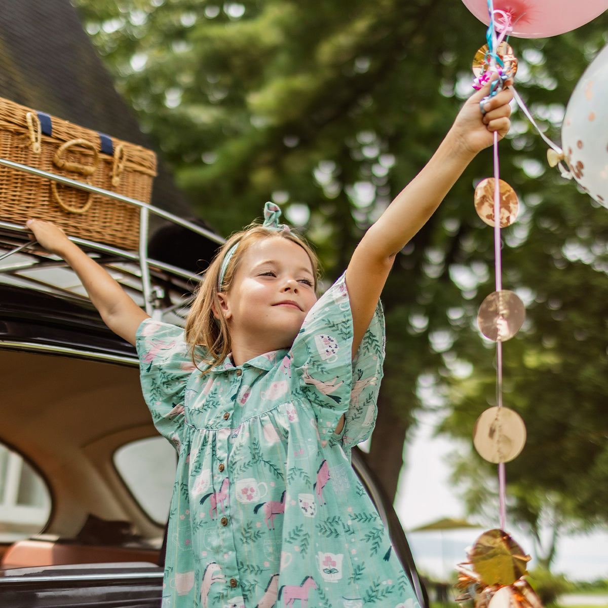 Photo d'un enfant portant la Combishort turquoise cendré en popeline scintillante à motifs de chevaux, enfant