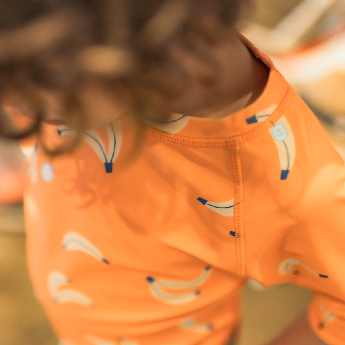 Orange rashguard with banana all over print, child