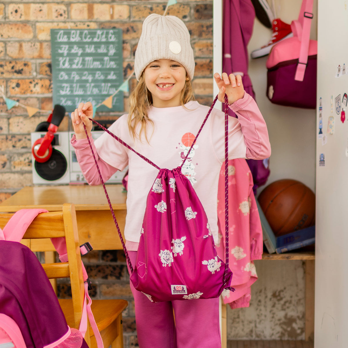 Photo d'un enfant présentant le sac tout usage rose foncé à motifs de chiens, enfant