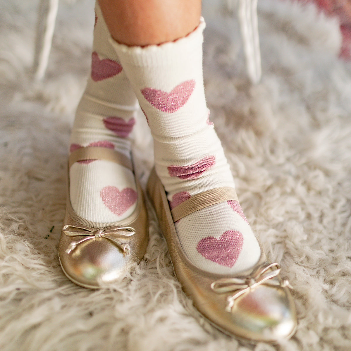 Photo d'un enfant portant les chaussettes crème à motifs de cœurs, enfant