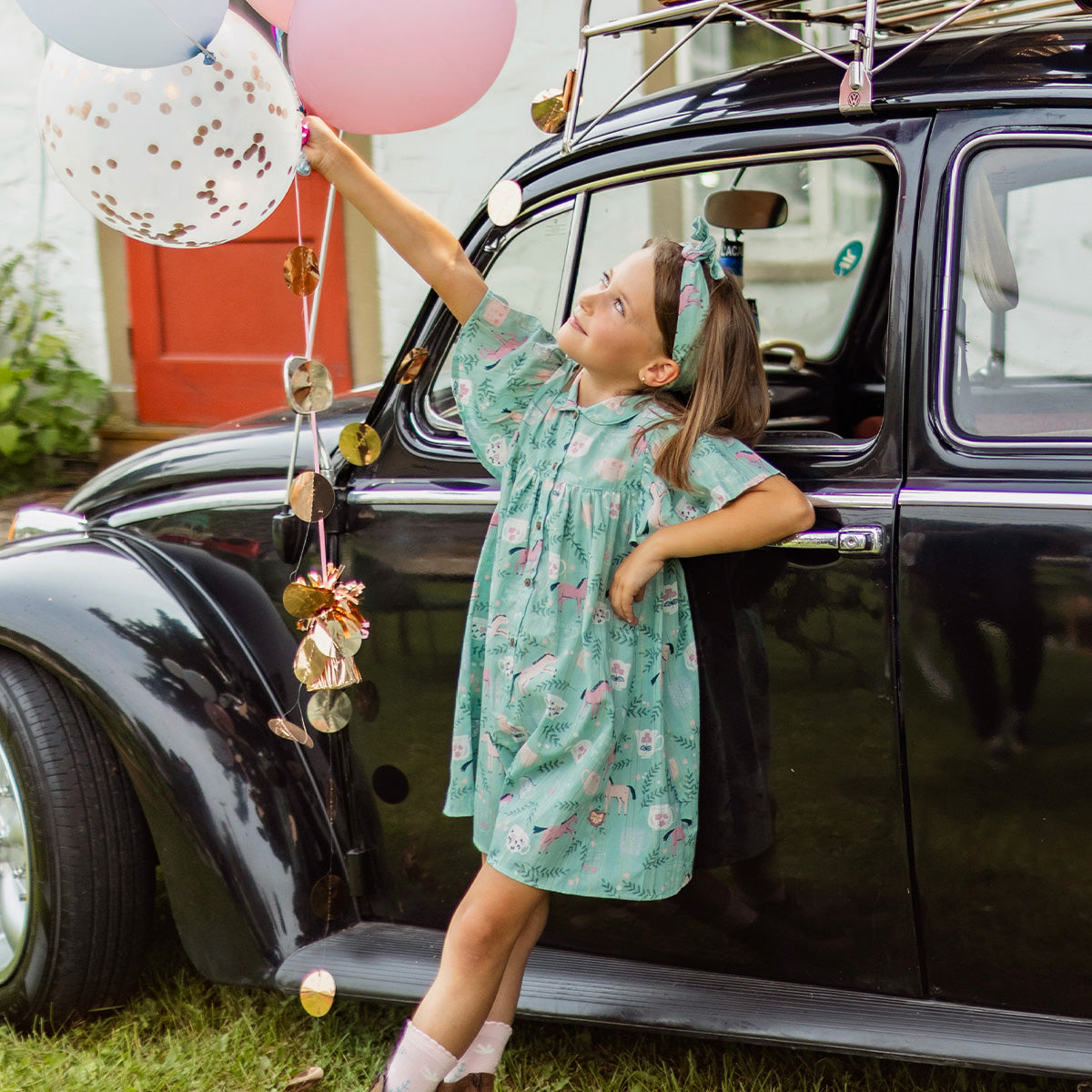 Photo d'un enfant portant la Combishort turquoise cendré en popeline scintillante à motifs de chevaux, enfant