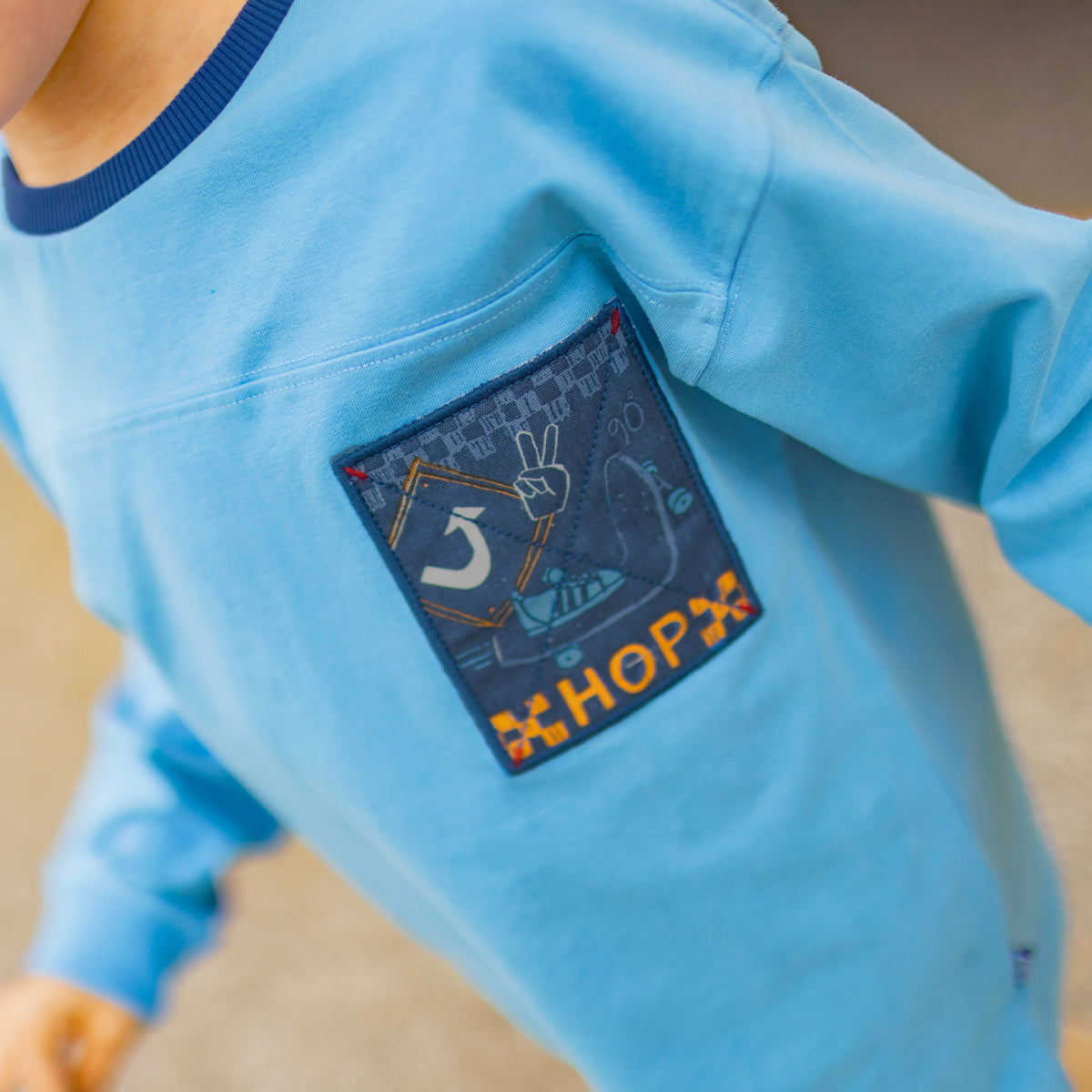 Photo d'un enfant portant le t-shirt bleu à illustration brodée, enfant