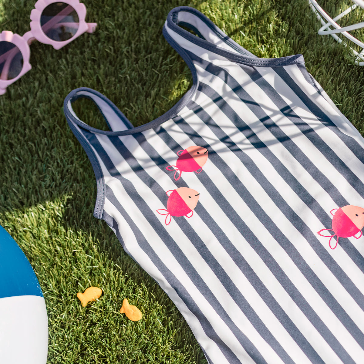 Look du maillot de bain une pièce blanc et bleu à rayures et poissons, enfant