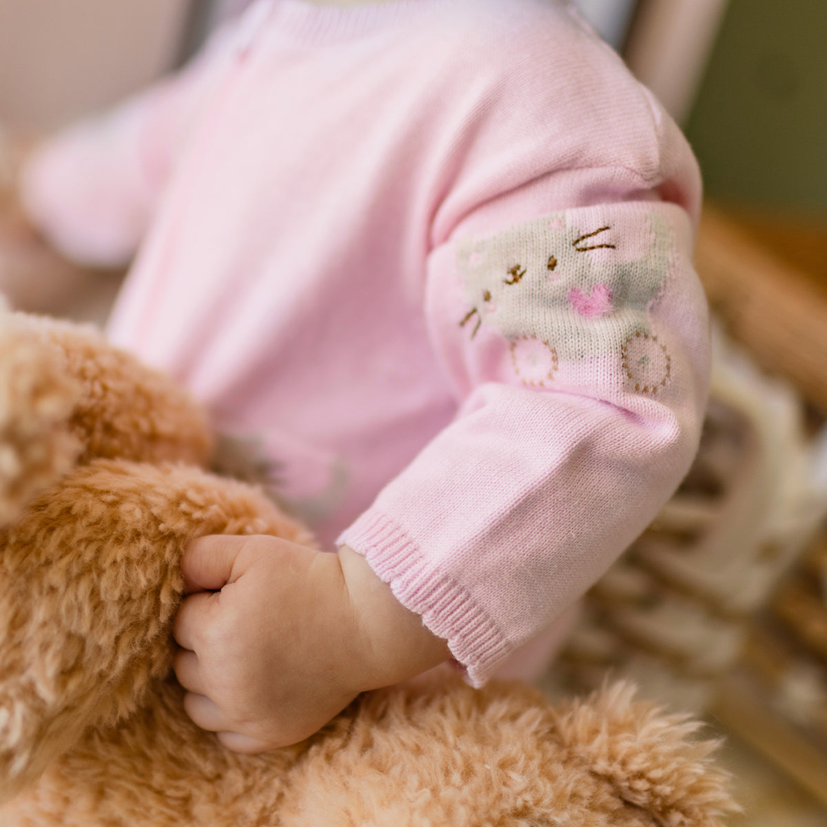 Zoom détails de l'une pièce rose en tricot avec motifs, naissance
