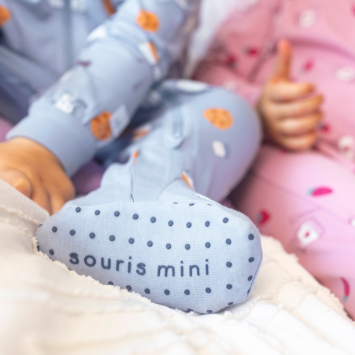 Gros plan des pieds intégrés antidérapants du pyjama une pièce bleu à petits motifs pour bébé en coton doux