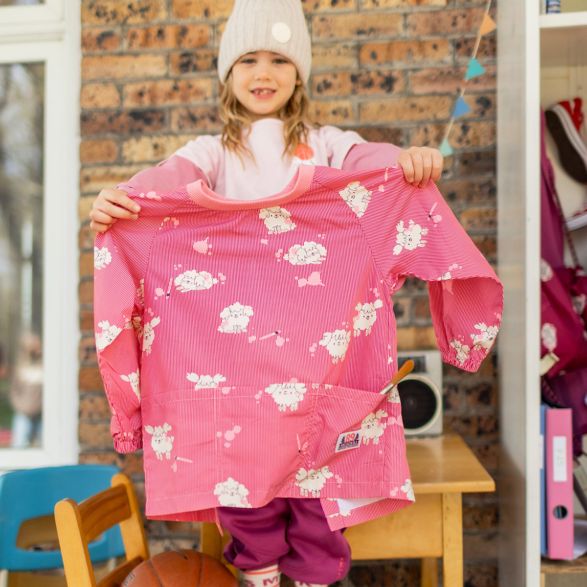 Photo d'un enfant présentant le couvre-tout rose à rayures et motifs de chiens, enfant