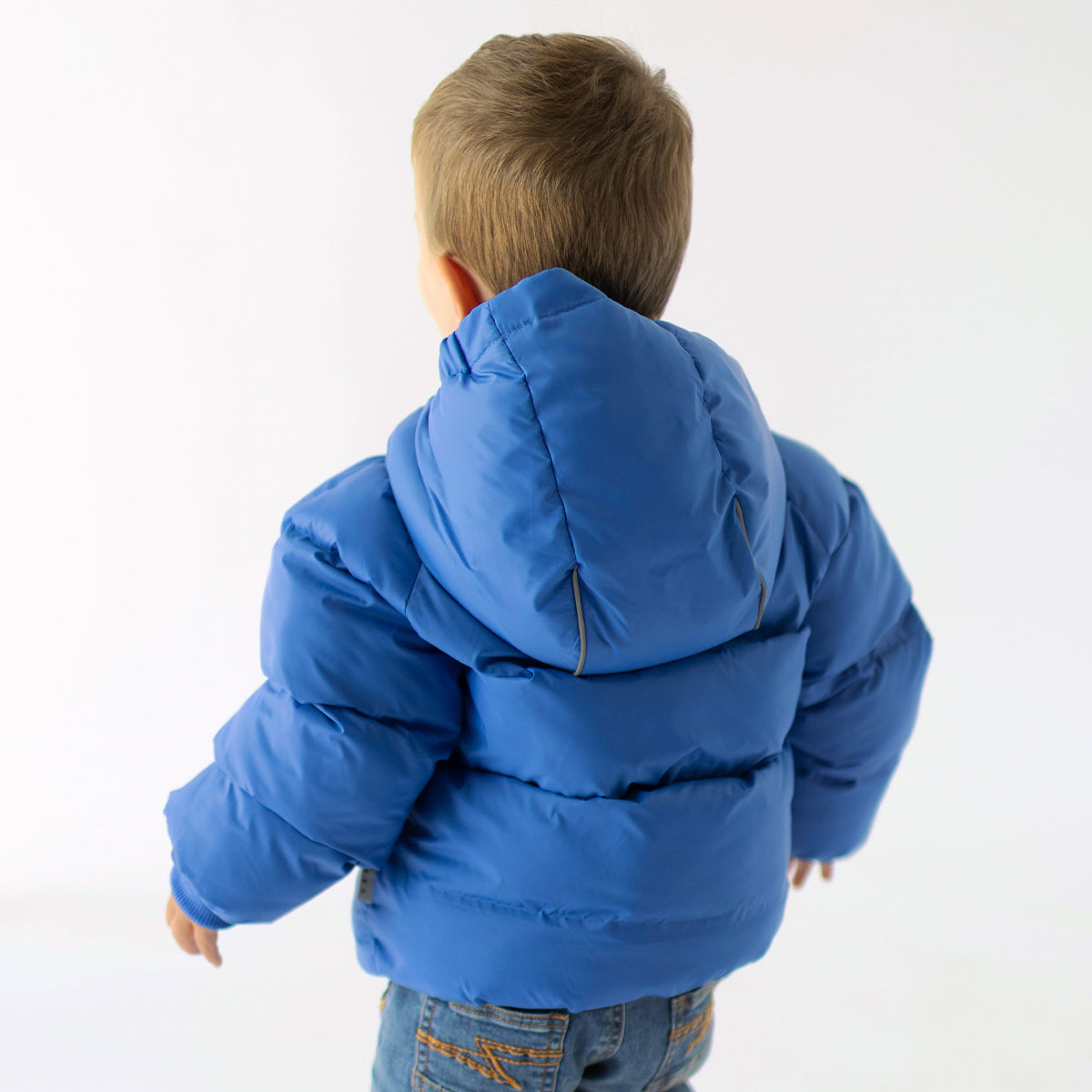 Photo de dos d'un enfant portant le manteau doudoune bleu, bébé