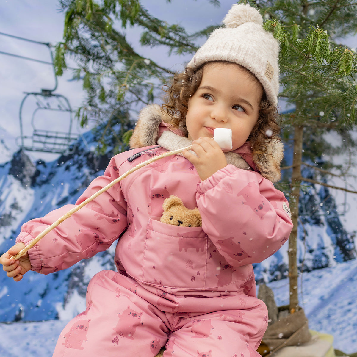 Photo d'un bébé portant l'habit de neige une pièce rose avec motifs, bébé