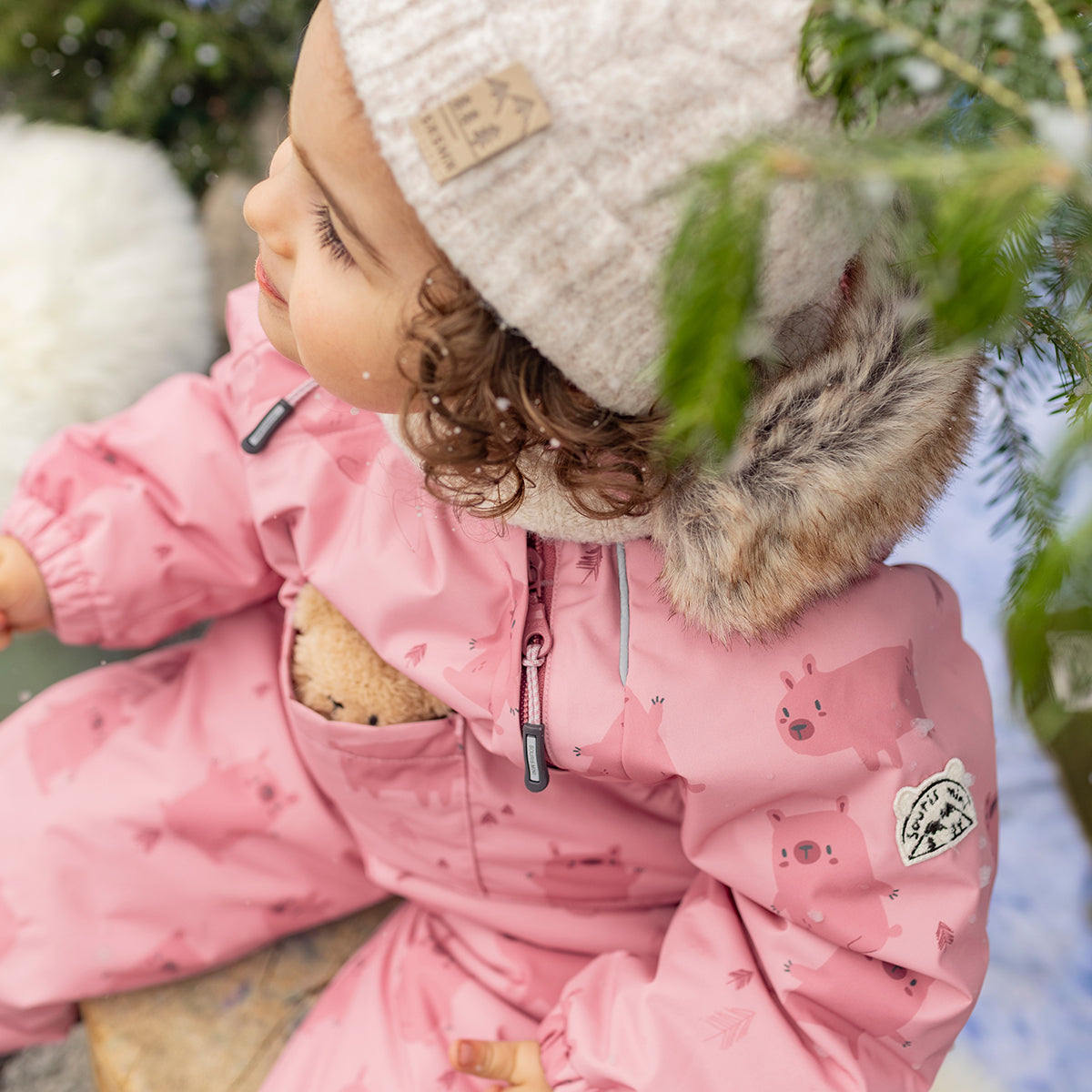 Photo d'un bébé portant l'habit de neige une pièce rose avec motifs, bébé