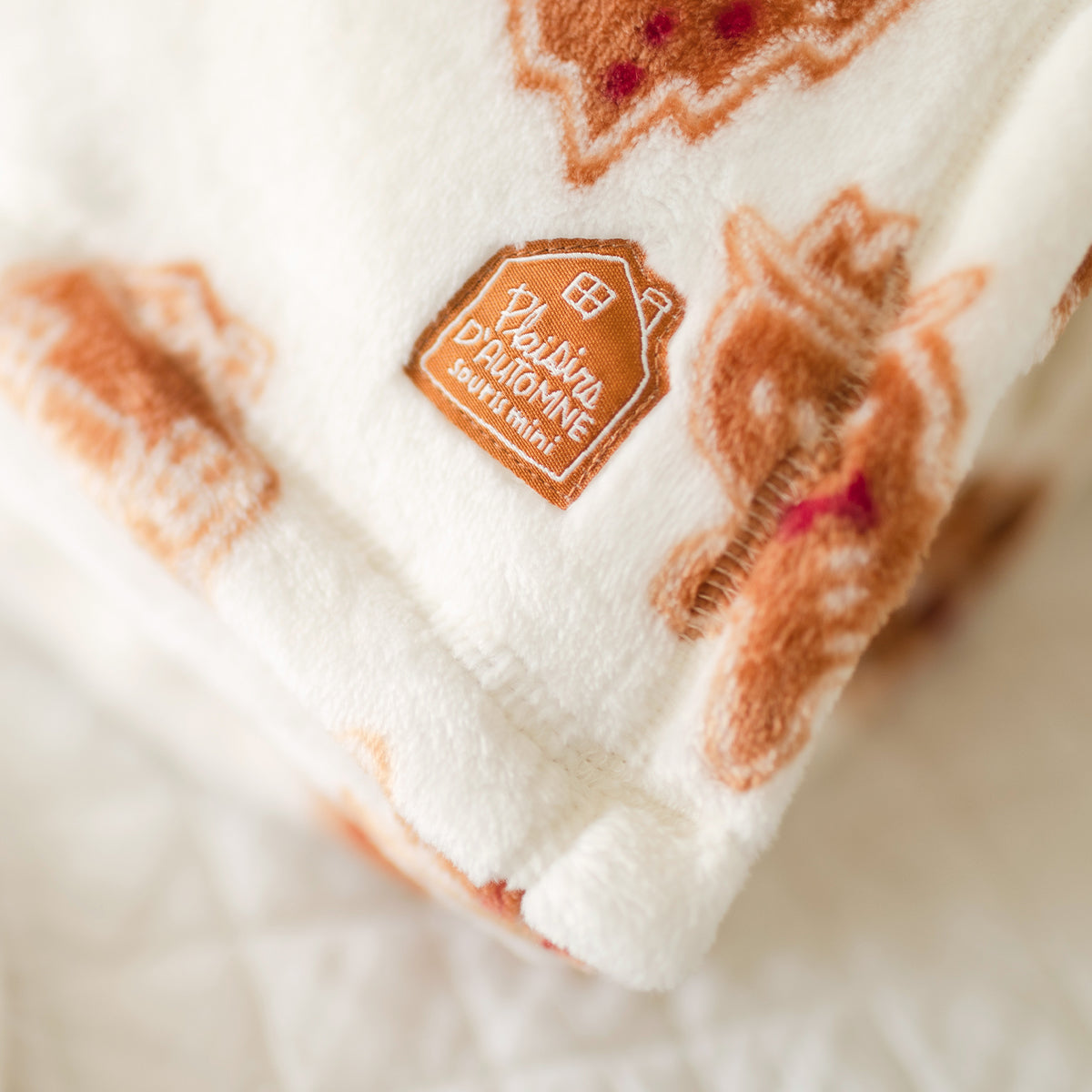 Présentation de la couverture en peluche crème à motifs pain d’épices