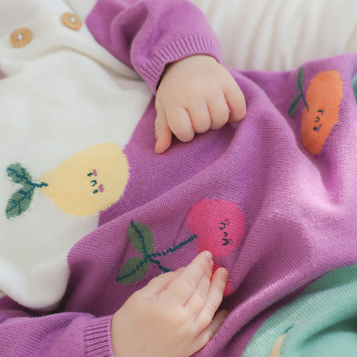 Cream, purple and turquoise knit jumpsuit with fruity patterns, newborn