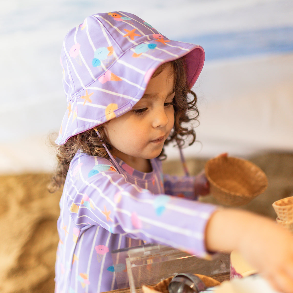 Chapeau de soleil réversible mauve avec rayures et motifs, bébé