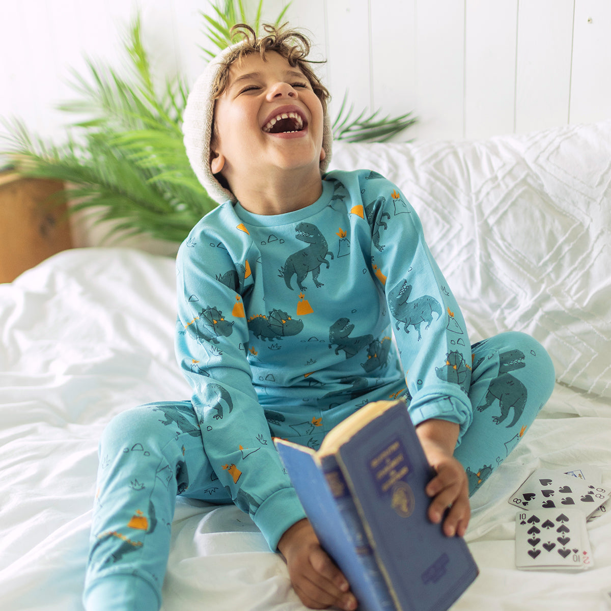 Photo d'un enfant portant le pyjama deux pièces turquoise à motifs de dinosaures, enfant