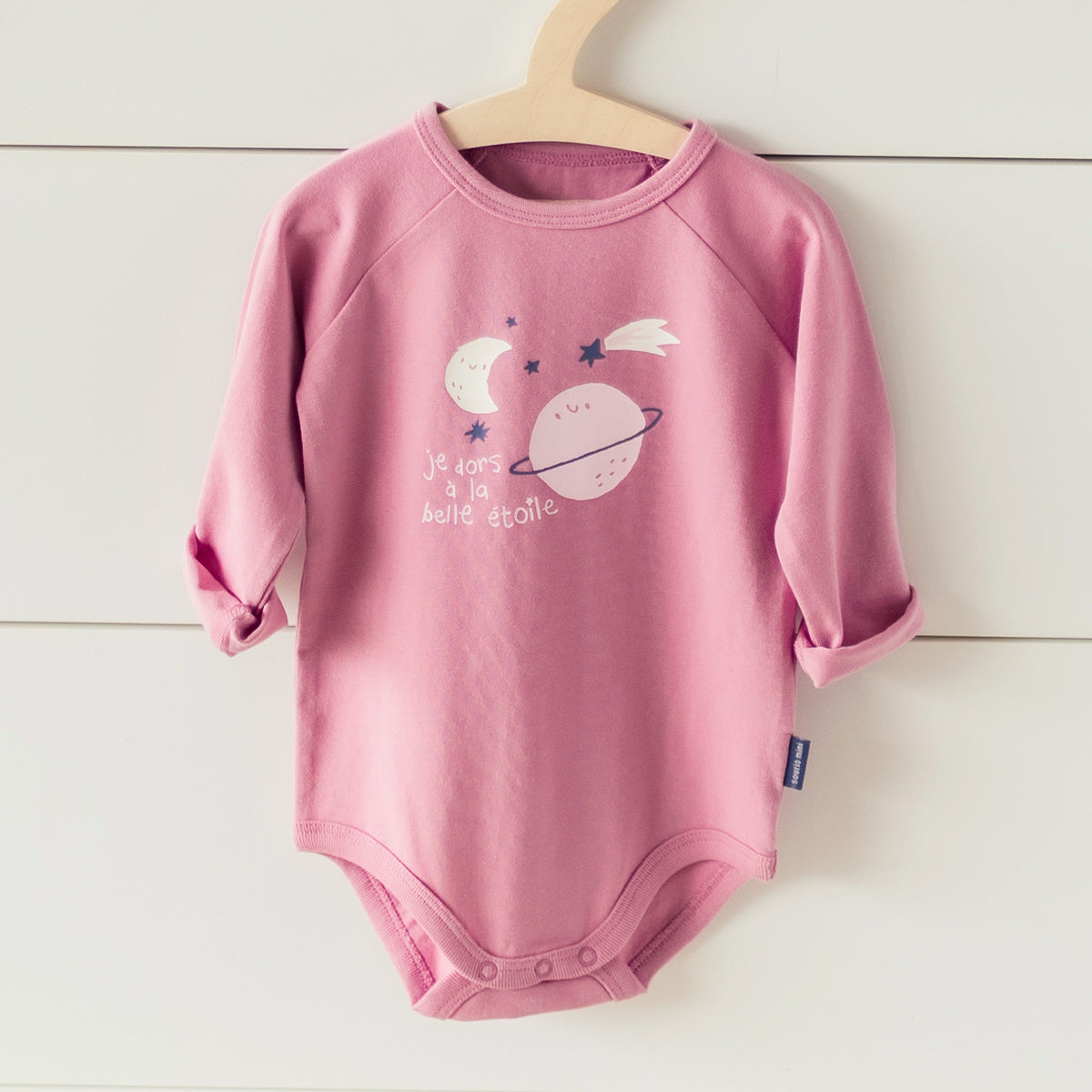 Présentation du cache-couche rose avec illustration de planète, bébé