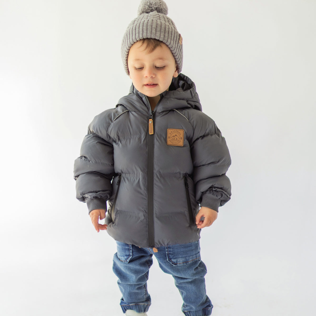 Photo d'un enfant portant un manteau doudoune gris foncé, bébé