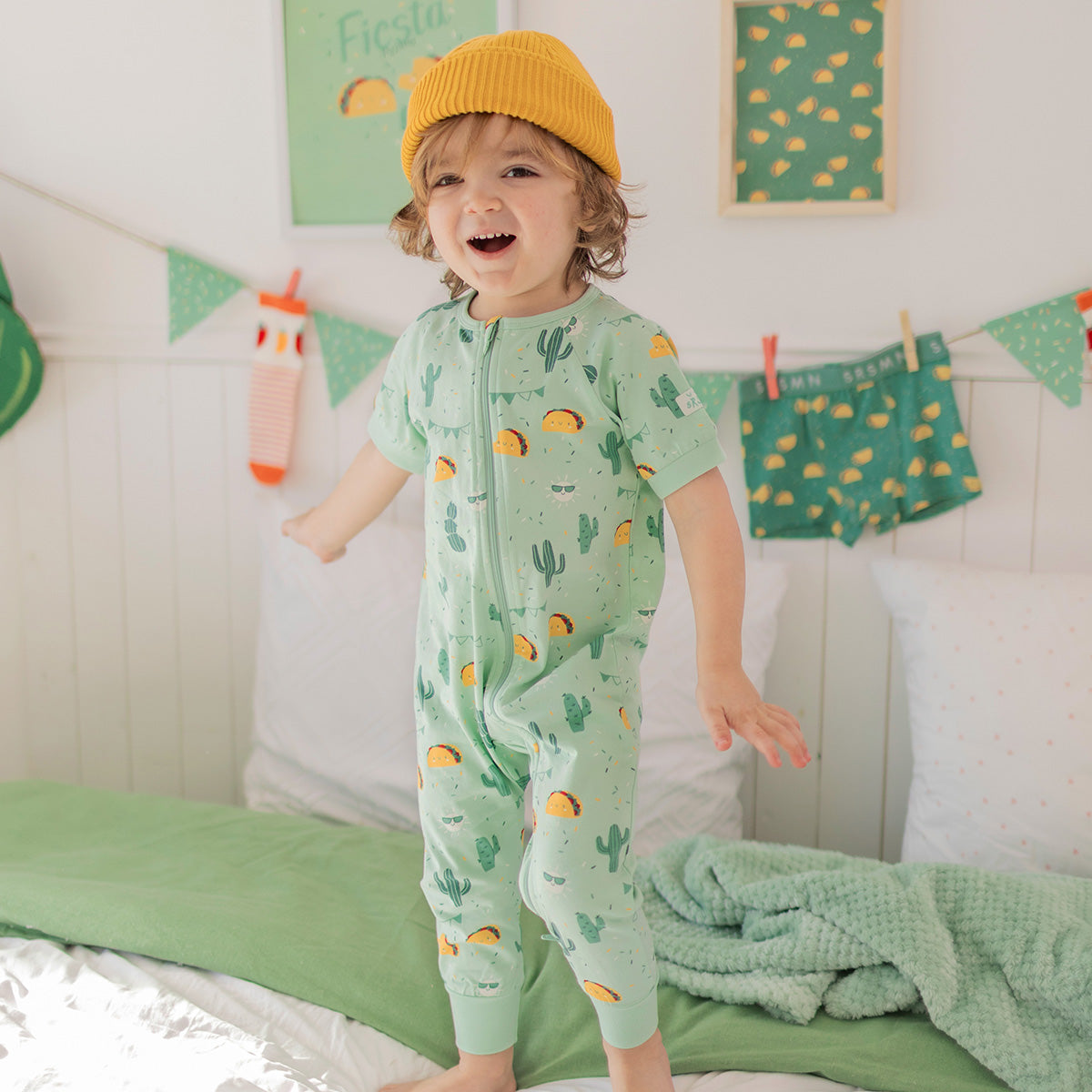 Green one-piece pajamas with fiesta print, baby