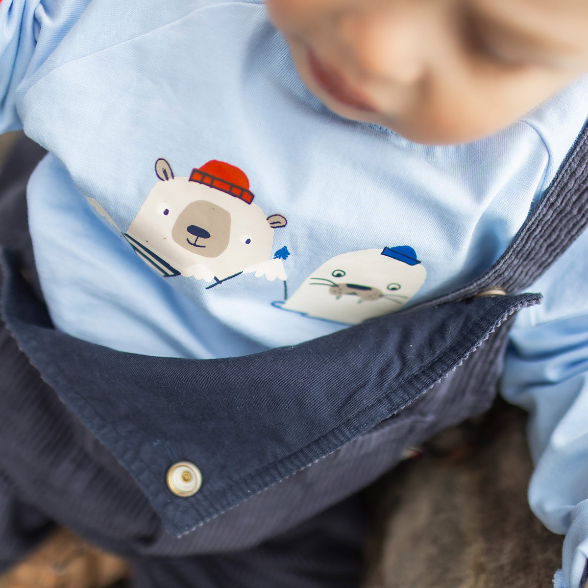 Photo d'un enfant portant le t-shirt bleu avec illustrations, bébé