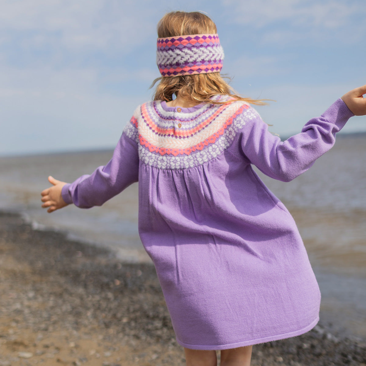 Photo de dos d'un enfant portant la robe mauve en tricot avec motifs, enfant