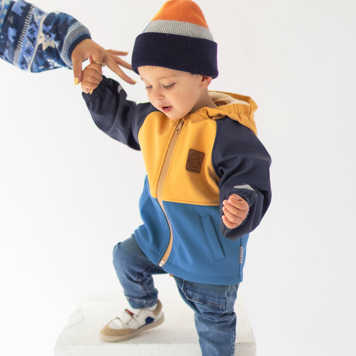 Photo d'un enfant portant le manteau bleu et jaune en coquille souple, bébé