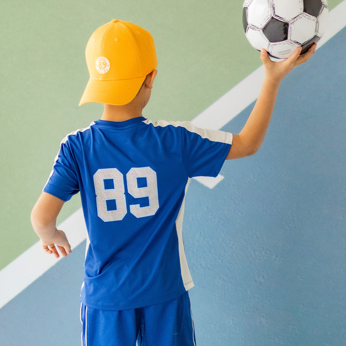 Photo de dos d'un enfant portant le t-shirt de sport bleu, enfant