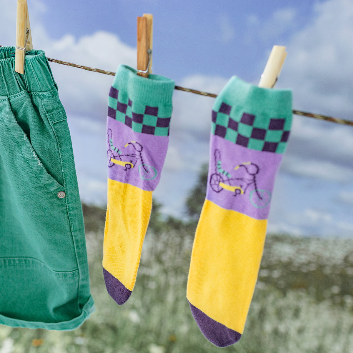Look des chaussettes jaunes, mauves et turquoise avec une bicyclette, enfant