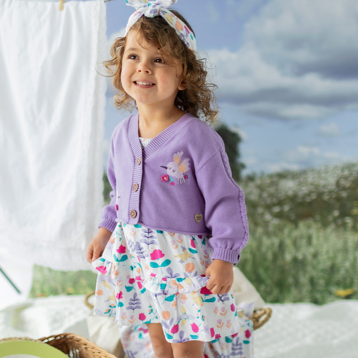 Look du cardigan de tricot mauve avec colibris, bébé