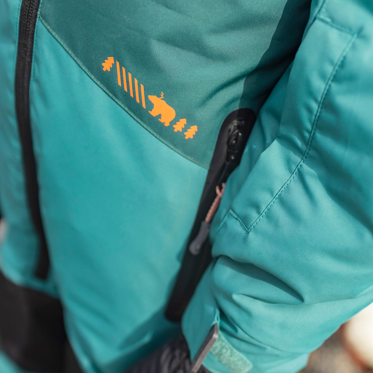 Zoom détails de l'habit de neige une pièce turquoise, enfant