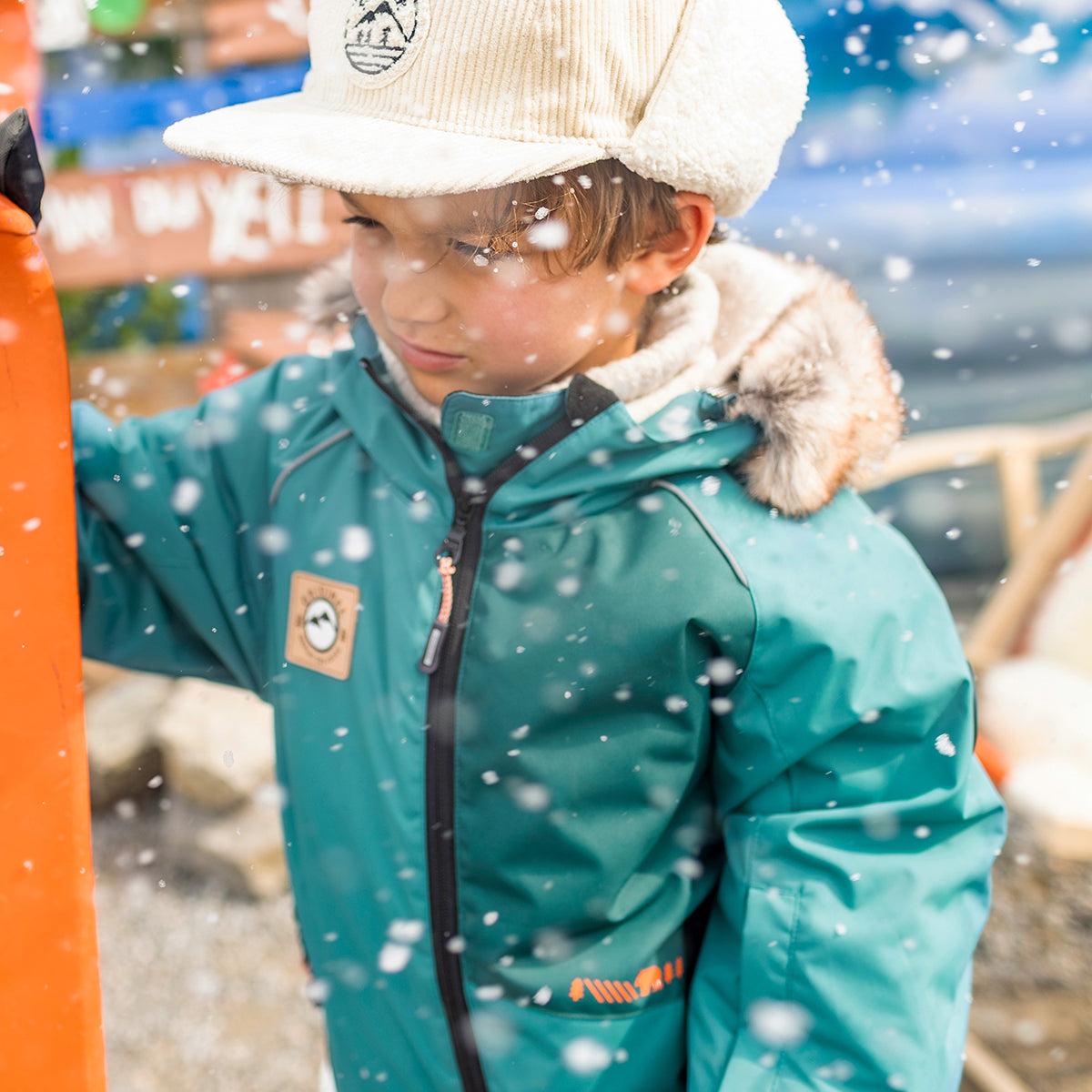Photo d'un enfant portant l'habit de neige une pièce turquoise, enfant