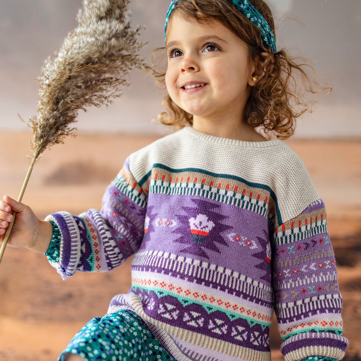 Photo d'un enfant portant le chandail beige et mauve en tricot, bébé