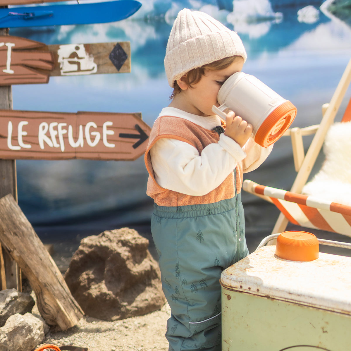 Photo d'un bébé portant l'habit de neige deux pièces vert avec motifs de sapins, bébé