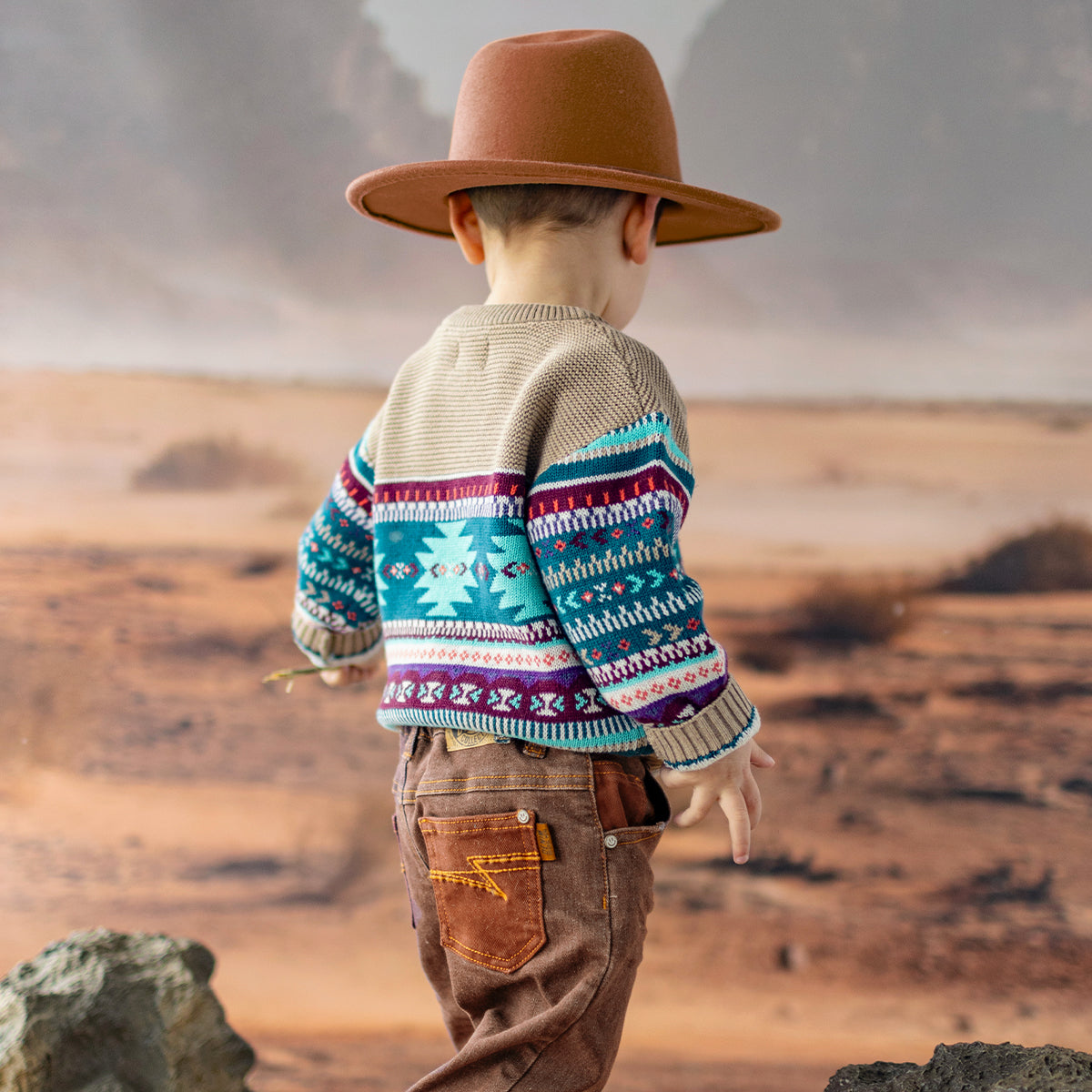 Photo d'un enfant de dos portant le chandail beige en tricot avec motifs, bébé