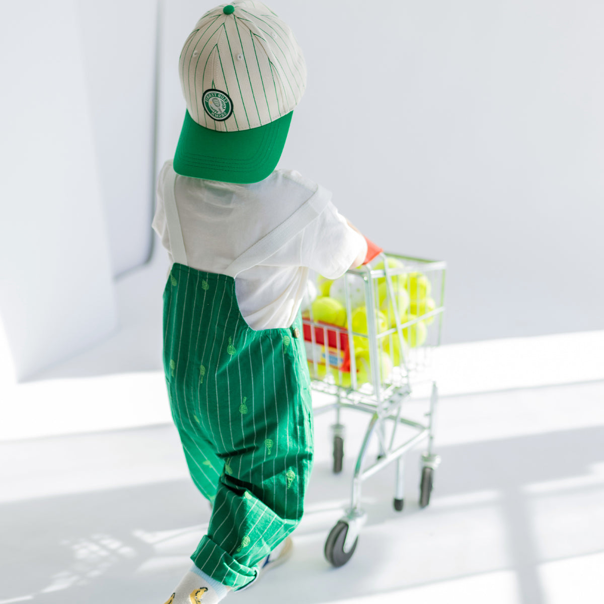 Look de dos de la salopette verte à rayures et motifs, bébé