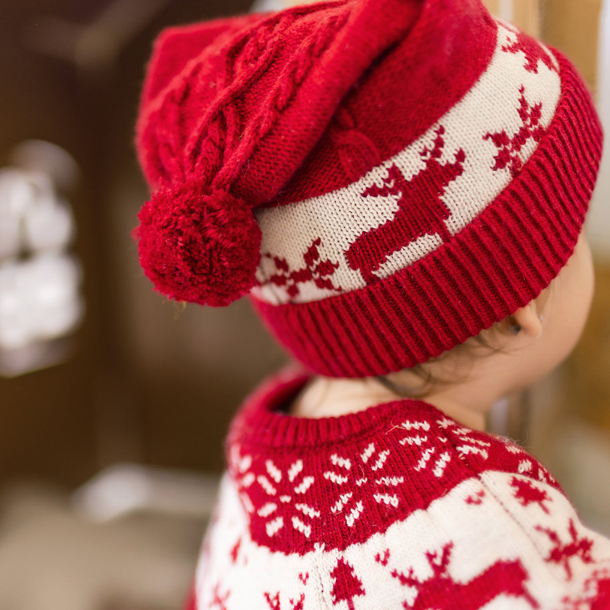 Photo d'un bébé de dos portant le bonnet rouge à motifs jacquard, naissance