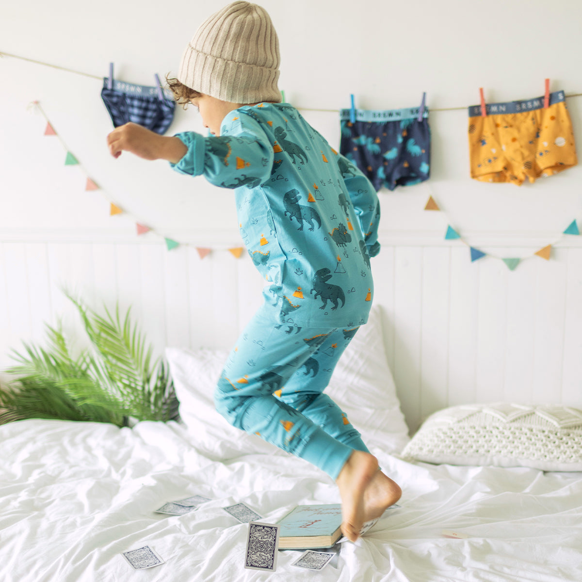 Photo d'un enfant portant le pyjama deux pièces turquoise à motifs de dinosaures, enfant