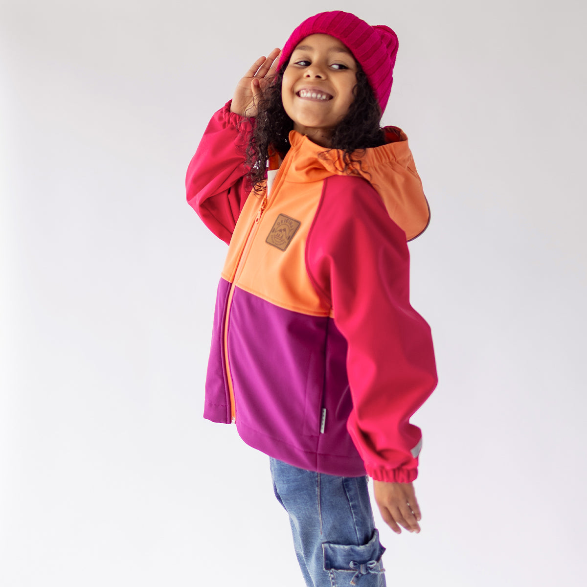 Photo d'un enfant portant le manteau mauve, rose et orange en coquille souple, enfant