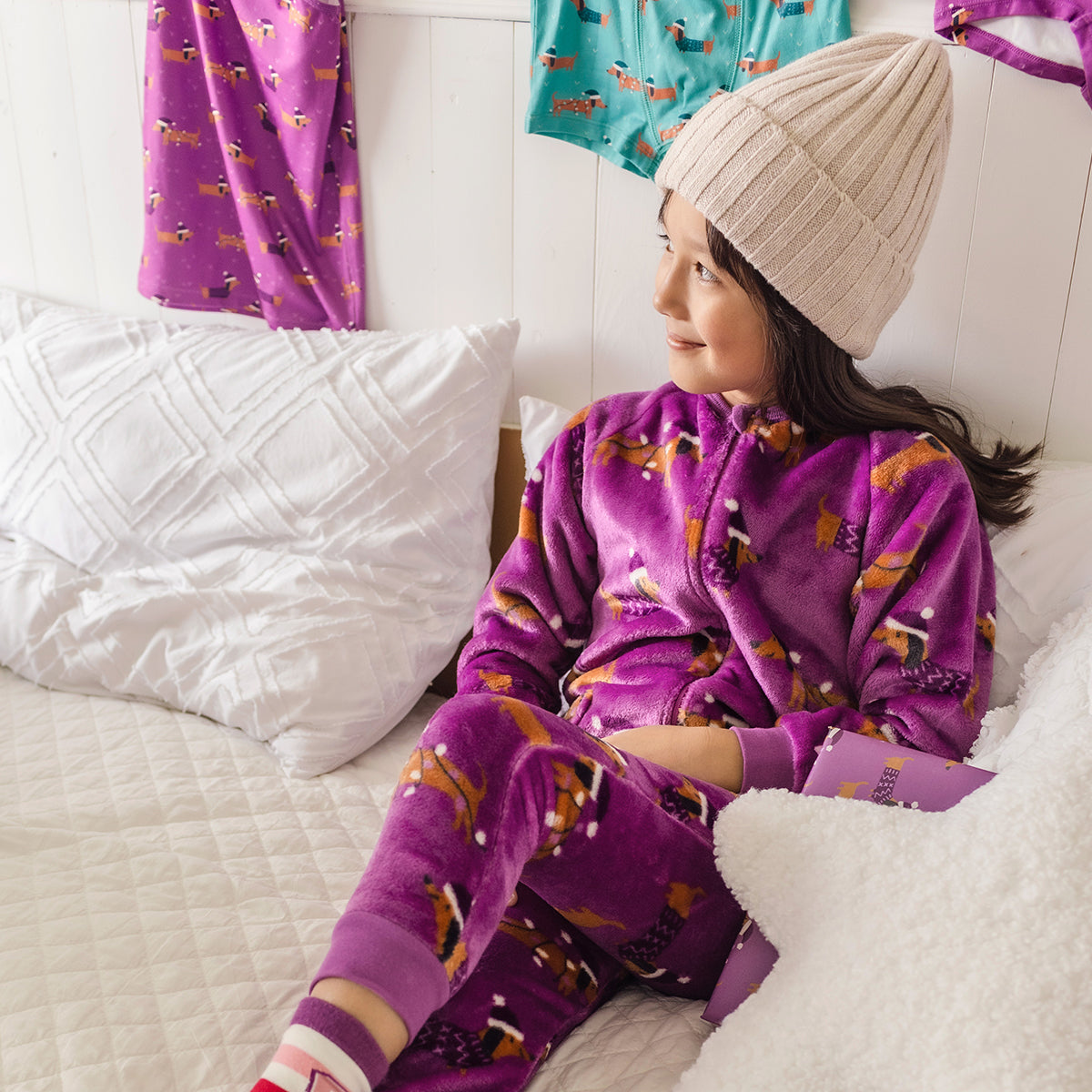 Image d'un enfant portant le pyjama une pièce mauve à motifs de chiens, enfant