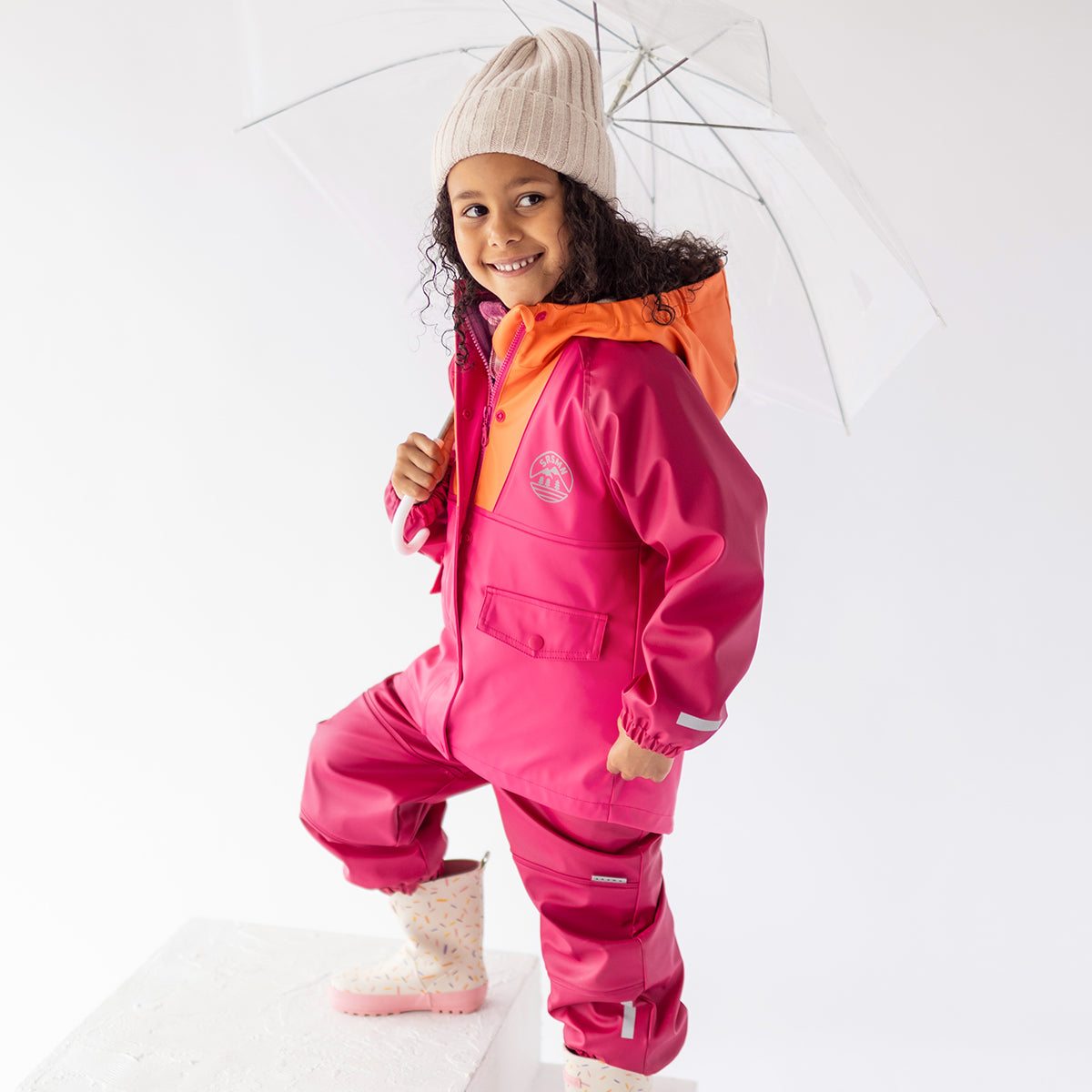 Photo d'un enfant portant la salopette de pluie rose, enfant