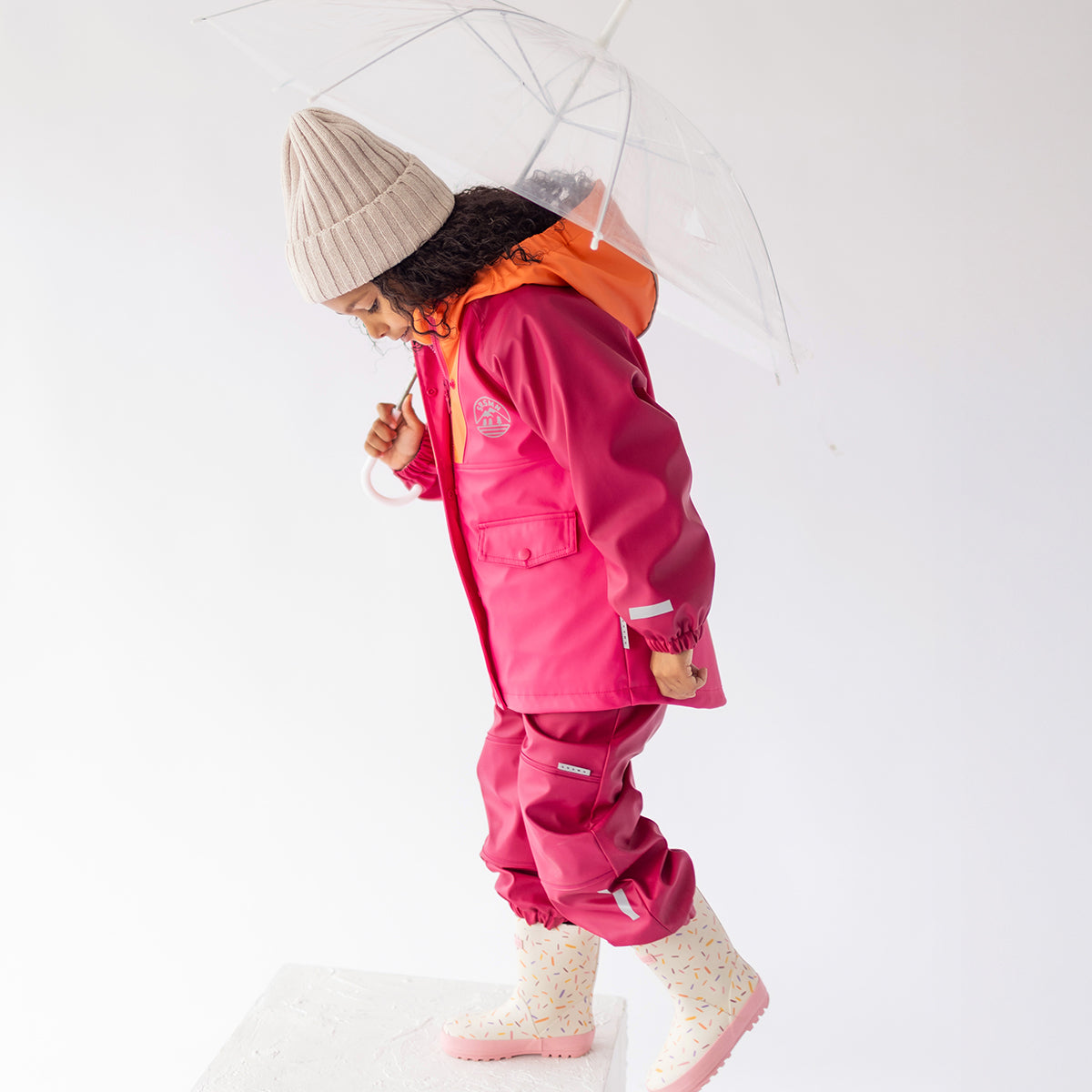 Photo d'un enfant portant la salopette de pluie rose, enfant