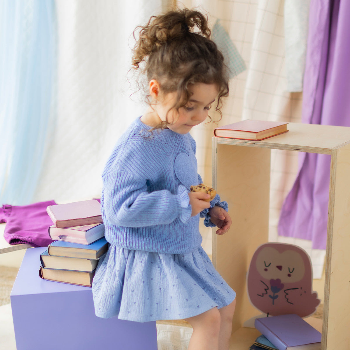 Chandail de maille bleu avec cœur pour bébé à manches longues, avec cœur texturé sur le devant, porté par un bébé.