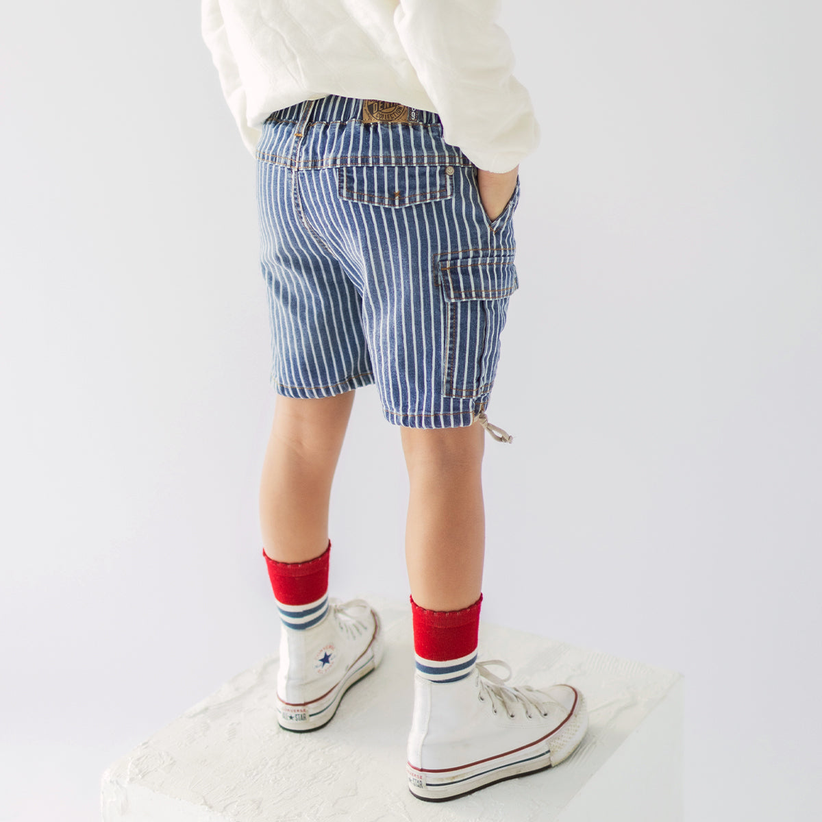 Photo d'un enfant portant le bermuda en denim bleu à rayures, enfant