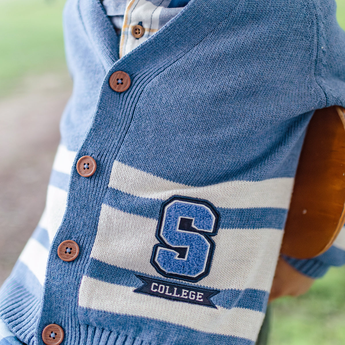 Zoom du cardigan bleu en tricot avec rayures, enfant