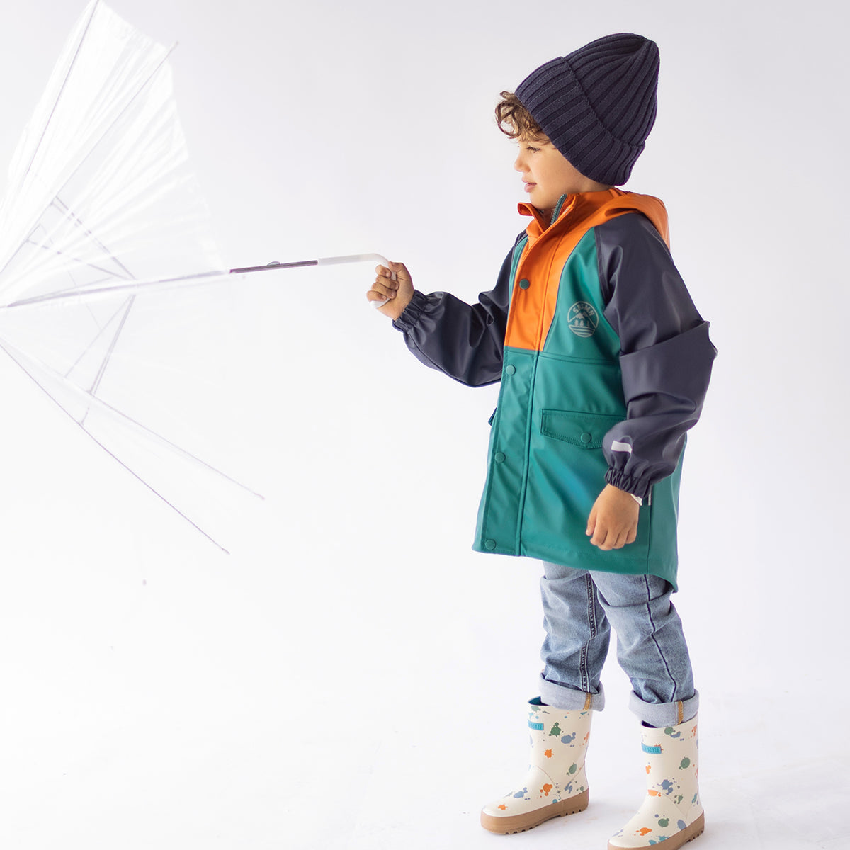 Photo d'un enfant portant le manteau imperméable bleu, turquoise et orange, enfant