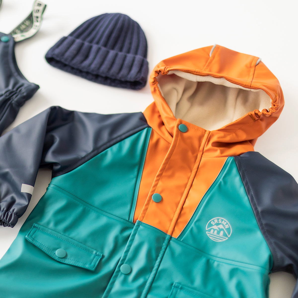 Présentation du manteau imperméable bleu, turquoise et orange, enfant