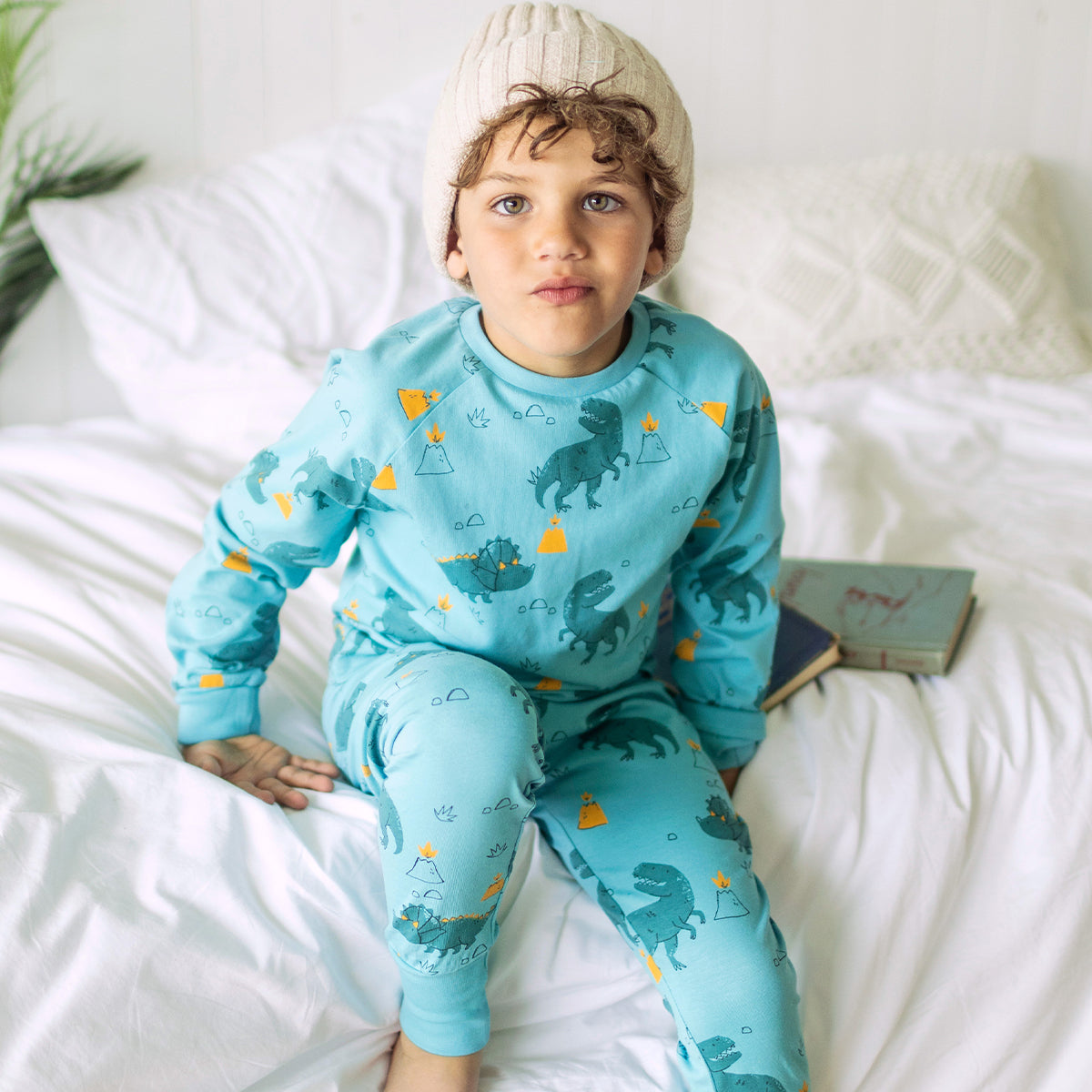 Photo d'un enfant portant le pyjama deux pièces turquoise à motifs de dinosaures, enfant